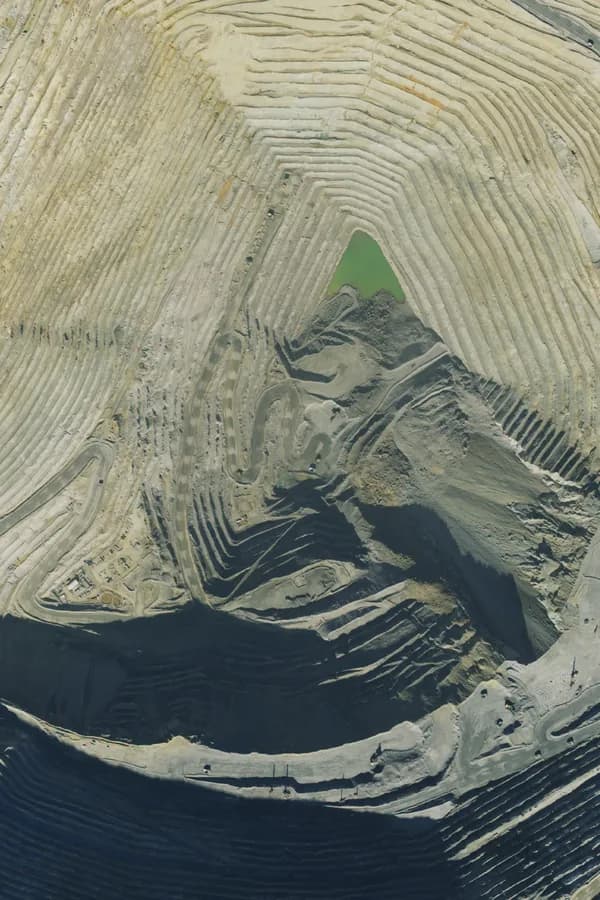 Aerial view of an open-pit copper mine, with haul roads cut into its terraced walls