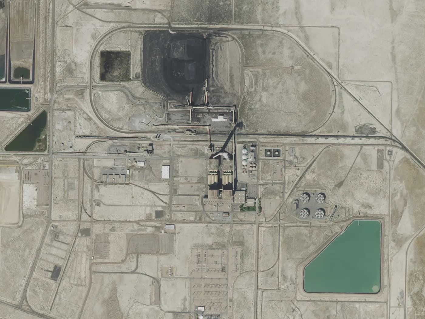 Aerial view of a power station with its switchyard, cooling basins and water pond